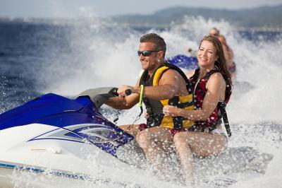 Happy adult couple enjoying ride on jetski