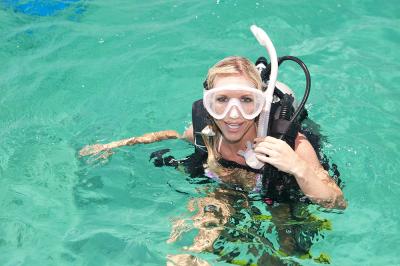 Smiling woman on the surface preparing for SCUBA dive